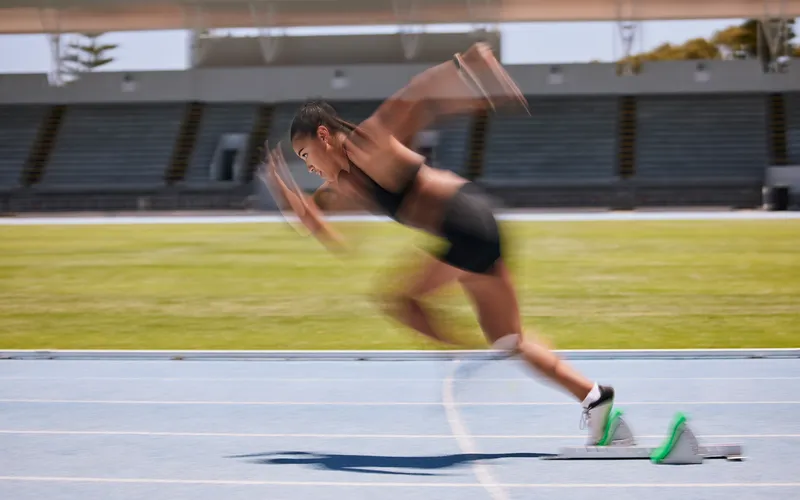 blurry motion captured of an athlete running on running track