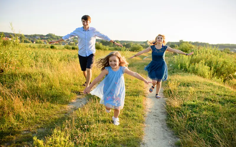 Family of three running together on the farm, photo taken sharply at 1/1250 sec shutter speed