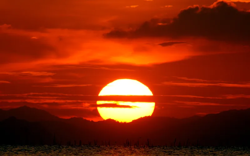 Deep red sun at sunset photographed at 1/2000 sec with a long lens to prevent camera shake