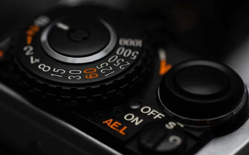 Photographer adjusting the shutter speed dial on a camera