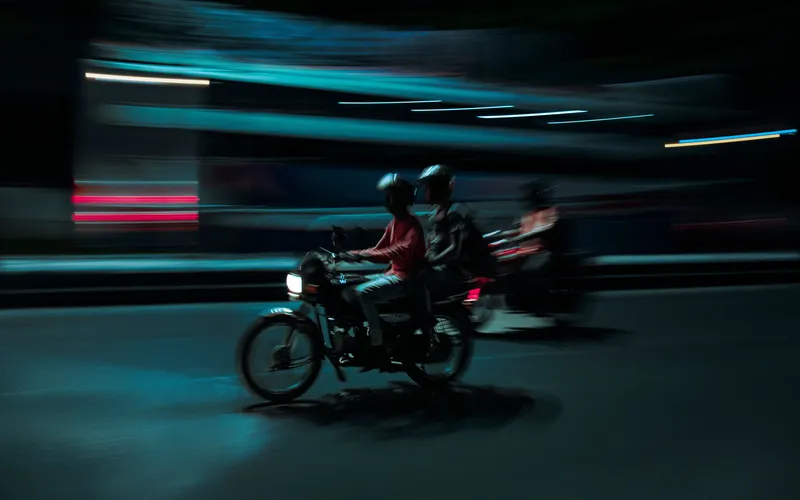 rider on a motorcycle captured with a panning shot, sharp subject against a blurred street background