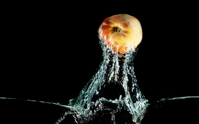 shot of an apple splashing water to demonstrate freeze motion in photography