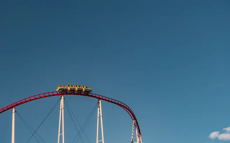 Roller coaster frozen mid-motion against a clear blue sky, an example of what a high shutter speed captures