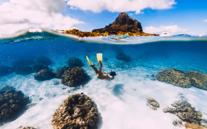 Woman snorkelling underwater, shot at 1/8000 sec to freeze the water's motion