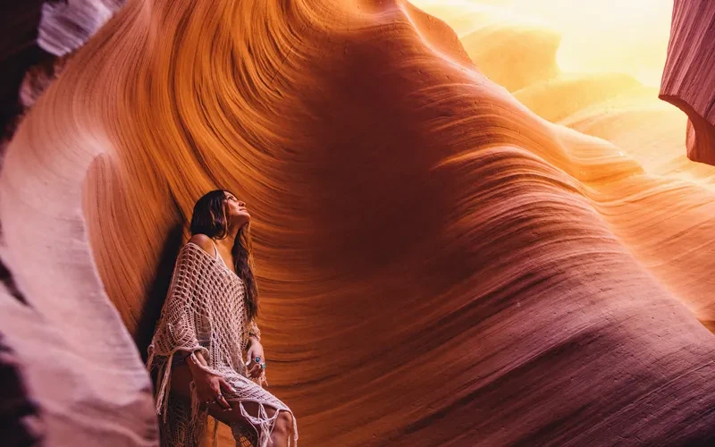 woman looking up at sunlight in cave antelope