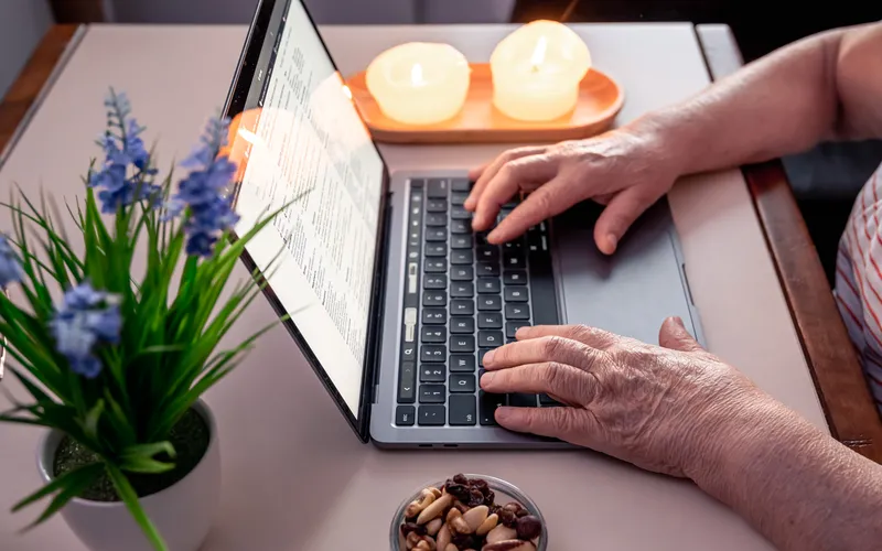 senior adult hands on laptop
