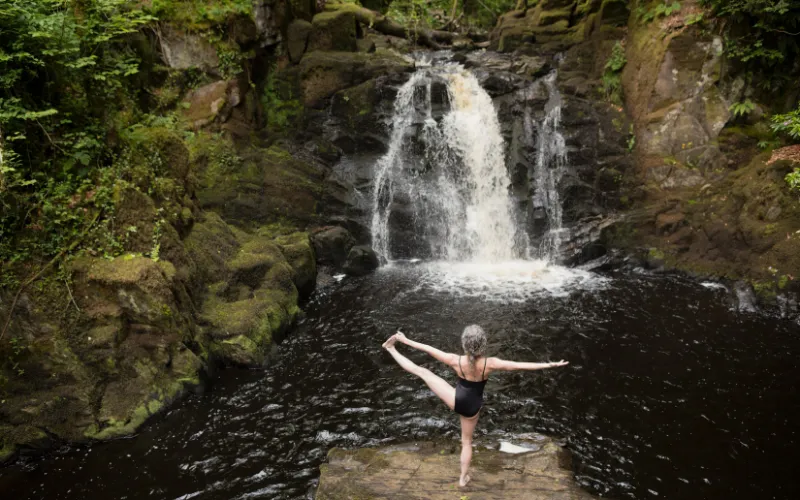 Nature-themed summer photoshoot at a waterfall with scenic backdrop