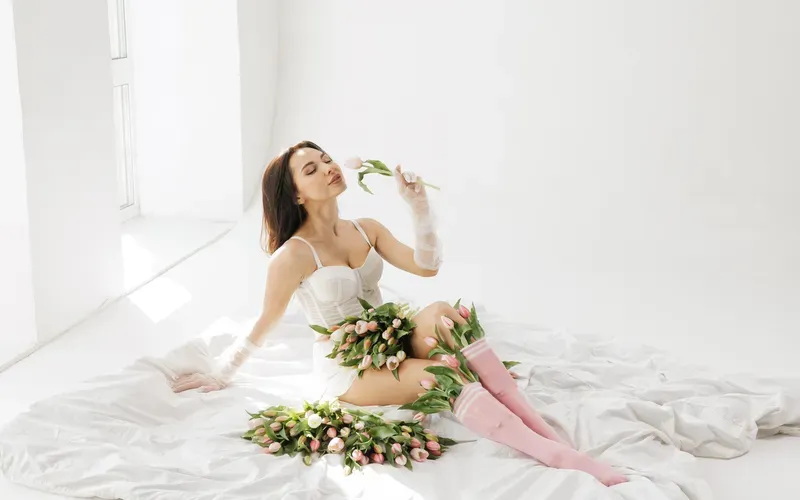 woman posing with tulips on white sheet