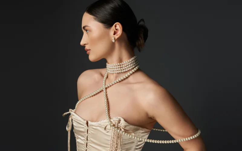 boudoir photography tips for photographers - woman posing wearing a corset and pearls