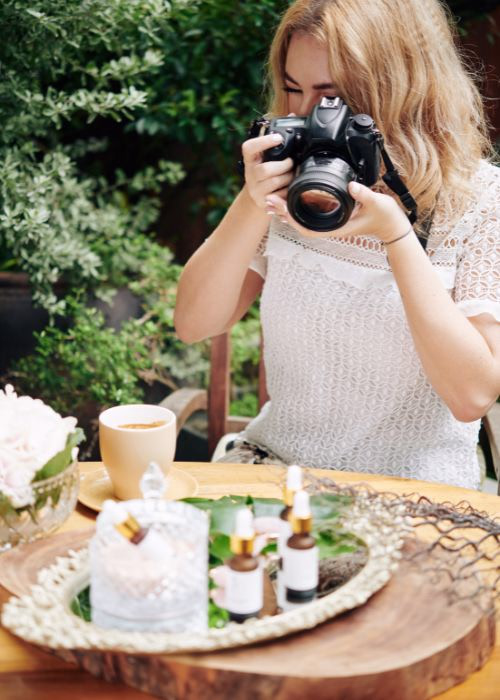 Female photographer capturing images with a DSLR camera, exploring whether photography will be replaced by AI in the coming years.
