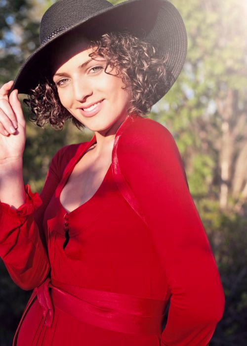 Outdoor portrait of a woman wearing a red dress and black hat, showcasing creative portrait photography and the future of photography with AI tools.