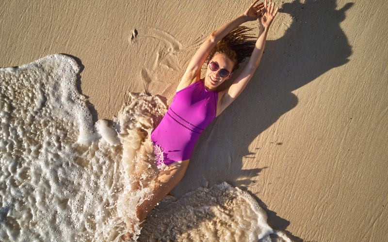 An overhead shot of a woman lying on the beach