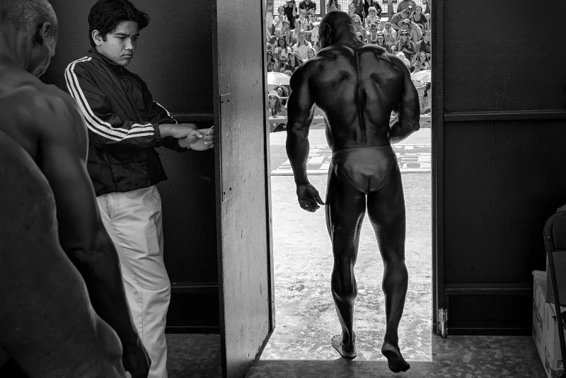Street portrait of a bodybuilder in an urban setting captured during a street photography course.