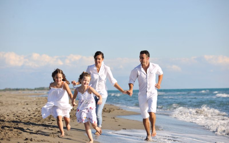 Parents chasing their kids along the shoreline