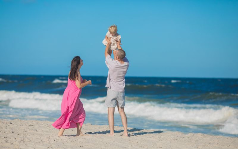 A couple lifting their kid in the air