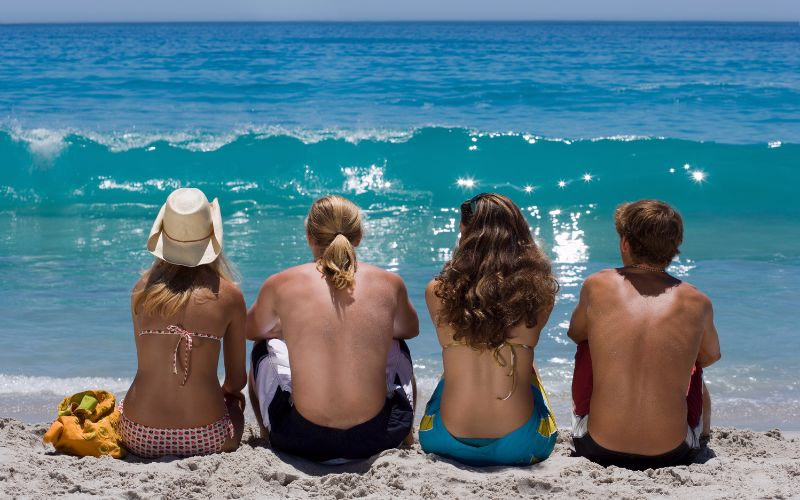 beach photoshoot poses of friends looking at the waves together