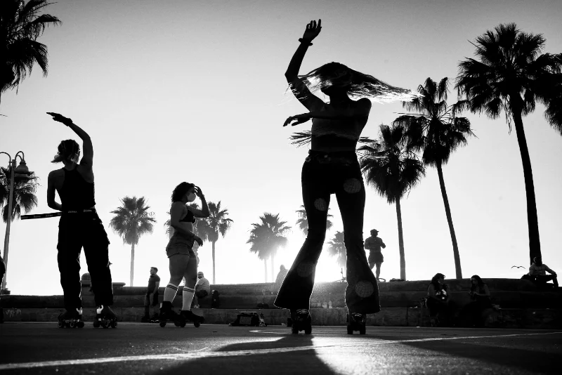 Silhouettes of skaters at sunset captured through creative street photography composition.