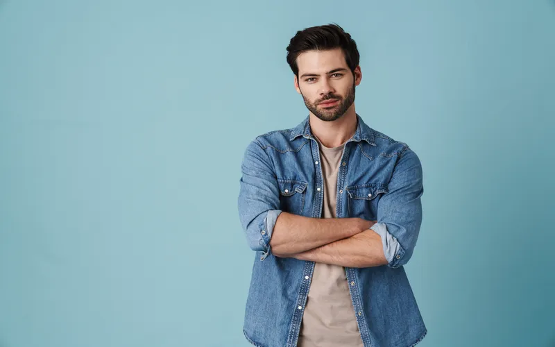Man in denim poses with arms crosesed