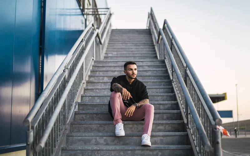man posing while sitting on stairs